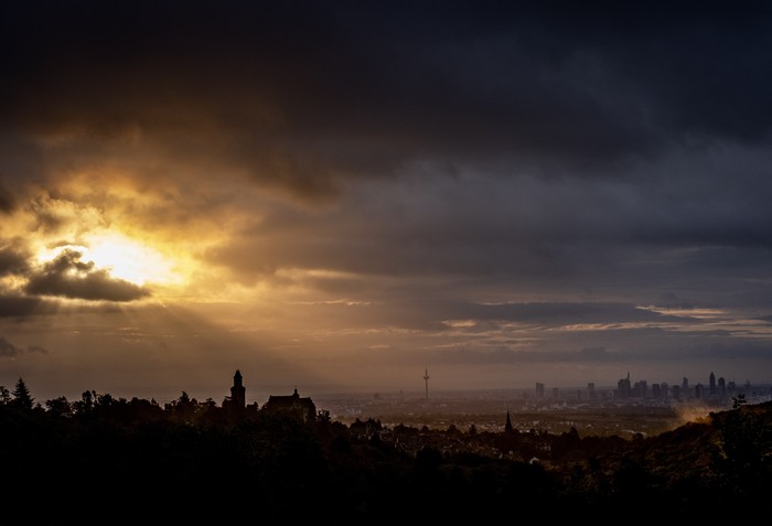 Ilustrasi senja The sun shines through clouds over the cities of Kronberg, left, and Frankfurt , Germany, Tuesday, Oct. 6, 2020. (AP Photo/Michael Probst)
