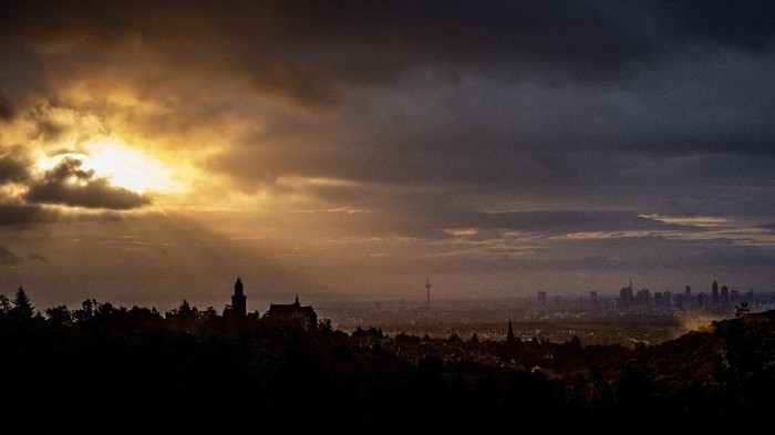 The sun shines through clouds over the cities of Kronberg, left, and Frankfurt , Germany, Tuesday, Oct. 6, 2020. (AP Photo/Michael Probst)