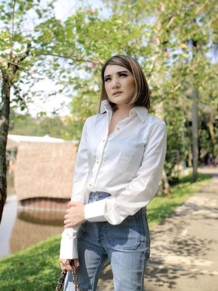 Meski hanya mengenakan kemeja putih dan celana jeans, penampilan Kiki tetap modis ya. (Foto: Instagram @kikiamaliaworld)