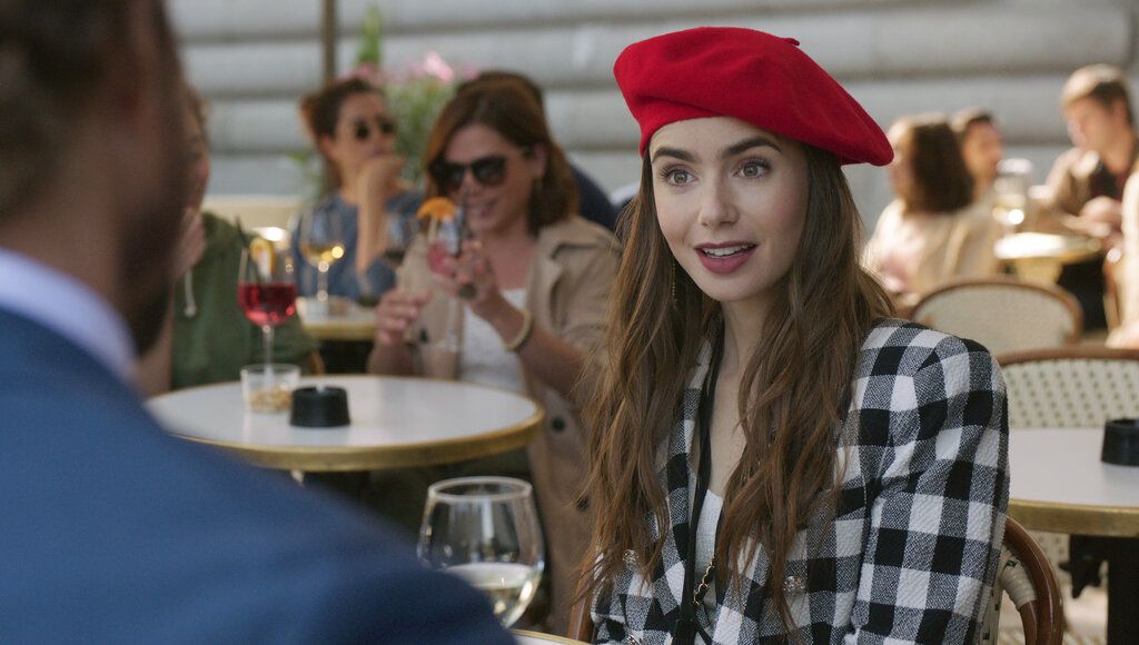This image released by Netflix shows William Abadie, left, and Lily Collins in a scene from the series 