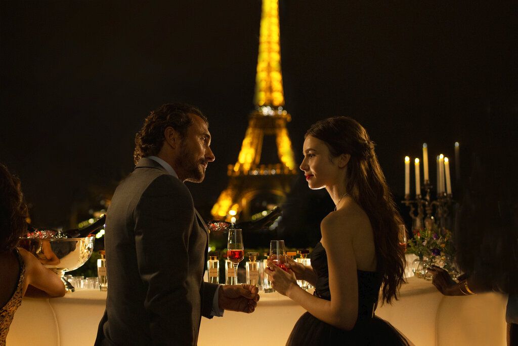This image released by Netflix shows William Abadie, left, and Lily Collins in a scene from the series 
