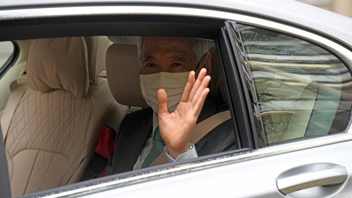 Singapores Prime Minister Lee Hsien Loong waves as he arrives in a car at the High Court in Singapore on October 6, 2020. (Photo by ROSLAN RAHMAN / AFP)