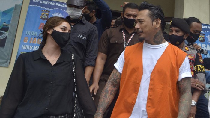Drummer Superman is Dead I Gede Ari Astina alias Jerinx (kanan) didampingi istrinya Nora Alexandra (kiri) meninggalkan ruangan usai menjalani sidang secara daring di Polda Bali, Denpasar, Bali, Selasa (22/9/2020). Pengadilan Negeri Denpasar menyelenggarakan sidang kedua kasus dugaan ujaran kebencian dan pencemaran nama baik yang dilaporkan Ikatan Dokter Indonesia (IDI) Bali tersebut dengan agenda pembacaan dakwaan kembali setelah pada sidang perdana lalu terdakwa Jerinx berserta kuasa hukumnya melakukan aksi walk out atau keluar dari persidangan. ANTARA FOTO/Fikri Yusuf/foc.