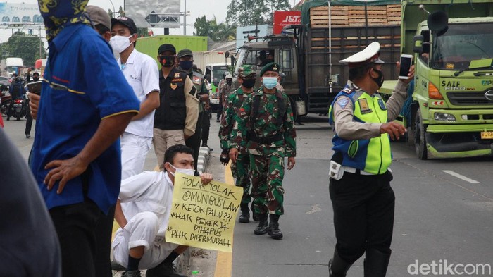 Aparat kepolisian dibantu TNI bersinergi mengamankan demo buruh di Jl Gatot Subroto, Kota Tangerang, Banten, Selasa (6/10/2020).