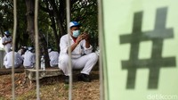 Para buruh yang mogok kerja berkumpul di area taman kawasan pabrik.