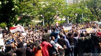 Barisan massa dari berbagai elemen termasuk mahasiswa itu di bagian depan lalu berpegangan ke pagar.