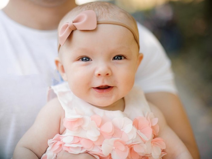 bayi perempuan Portrait of a beautiful baby girl with the black band on her head lying on the sofa