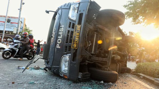 Petugas menyaksikan mobil polisi yang rusak usai bentrokan antara massa aksi tolak UU Omnibus Law Cipta Kerja dengan polisi di kawasan Penjernihan, Jakarta, Rabu (7/10/2020). CNBC Indonesia/Andrean Kristianto