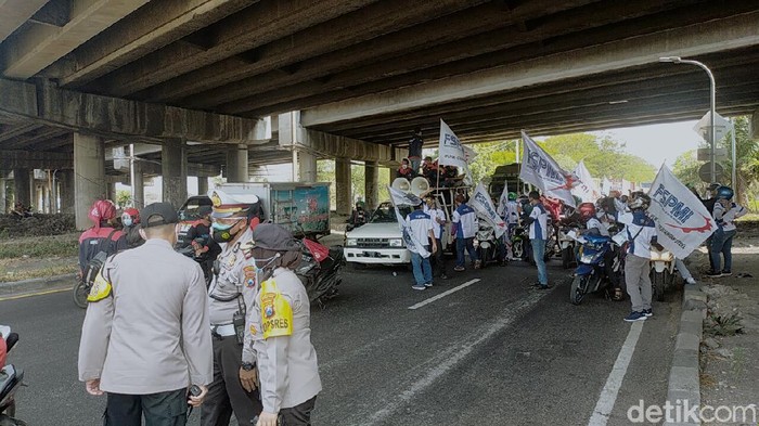 Puluhan buruh yang tergabung dalam Federasi Serikat Pekerja Metal Indonesia (FSPMI) menggelar aksi di Jalan Margomulyo. Mereka konvoi sambil menyuarakan penolakan UU Ombimbus Law Cipta Kerja.