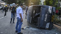 Petugas menyaksikan mobil polisi yang rusak usai bentrokan antara massa aksi tolak UU Omnibus Law Cipta Kerja dengan polisi di kawasan Penjernihan, Jakarta, Rabu (7/10/2020).