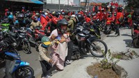 Pengendara yang terjebak kemacetan di jalan nasional Bandung-Garut-Tasikmalaya saat aksi buruh di Rancaekek mengangkat motornya untuk pindah jalur, Selasa (6/10/2020). ANTARA FOTO/Raisan Al Farisi  