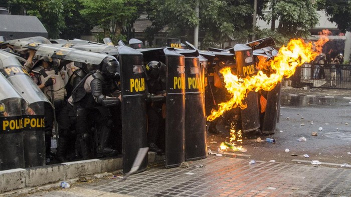 Personil Kepolisian menahan lemparan molotov oleh demonstran saat unjuk rasa tolak Undang-Undang Cipta Kerja di Depan Gedung DPRD Jawa Barat, Bandung, Jawa Barat, Rabu (7/10/2020). Aksi yang menolak dan menuntut pembuatan Perppu untuk Undang-Undang Cipta Kerja tersebut berakhir ricuh. ANTARA FOTO/Novrian Arbi/foc.