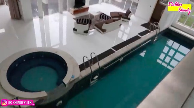 Salah satu keunikan di rumah incaran Ria Ricis ini adalah kolam renang yang berada di dalam rumah. Kolam memanjang itu juga dilengkapi sebuah jacuzzi. (Foto: YouTube/Dokter Shindy)