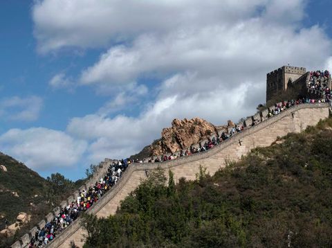 Tembok Besar China Penuh Wisatawan Saat Libur Nasional BEIJING, CHINA - OCTOBER 04: A Chinese tourist poses as her photo is taken by a friend as they visit a crowded section of the Great Wall at Badaling after tickets sold out during the 'Golden Week' holiday on October 4, 2020 in Beijing, China. Officials are expecting the Golden Week holiday to boost China's consumer economy as people were encouraged to use the eight-day break to travel and spend. Tourist sites including the Great Wall were packed, with tickets selling out most days given pandemic restrictions and capacity capped at 75%. (Photo by Kevin Frayer/Getty Images)