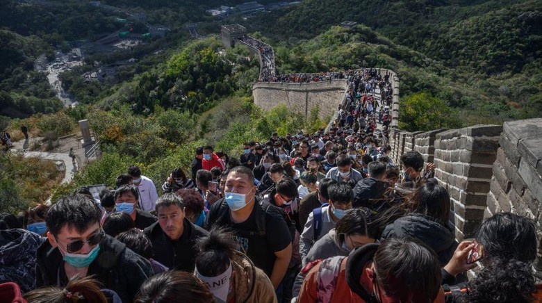 Tembok Besar China Penuh Wisatawan Saat Libur Nasional BEIJING, CHINA - OCTOBER 04: A Chinese tourist poses as her photo is taken by a friend as they visit a crowded section of the Great Wall at Badaling after tickets sold out during the Golden Week holiday on October 4, 2020 in Beijing, China. Officials are expecting the Golden Week holiday to boost Chinas consumer economy as people were encouraged to use the eight-day break to travel and spend. Tourist sites including the Great Wall were packed, with tickets selling out most days given pandemic restrictions and capacity capped at 75%. (Photo by Kevin Frayer/Getty Images)