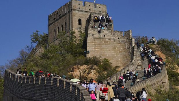 Tourists pose for photos along a stretch of the Badaling Great Wall of China on the outskirts of Beijing, Tuesday, Oct. 6, 2020. Chinese tourists took 425 million domestic trips in the first half of the eight-day National Day holiday, generating $45.9 billion in tourism revenue, according to China's ministry of culture and tourism. The holiday this year, which coincides with the Mid-Autumn Festival, will be a litmus test of whether China's tourism industry can bounce back after being battered by COVID-19. (AP Photo/Ng Han Guan)