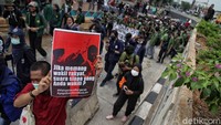 Seorang pengunjuk rasa membentangkan poster menolak omnibus law.  
