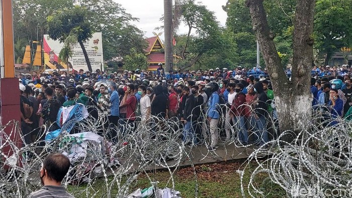 Ambulans bertuliskan FPI ditahan aparat karena menerobos kerumunan massa yang demo tolak Omnibus Law di DPRD Riau. Dua orang diamankan (Chaidir Tanjung/detikcom)