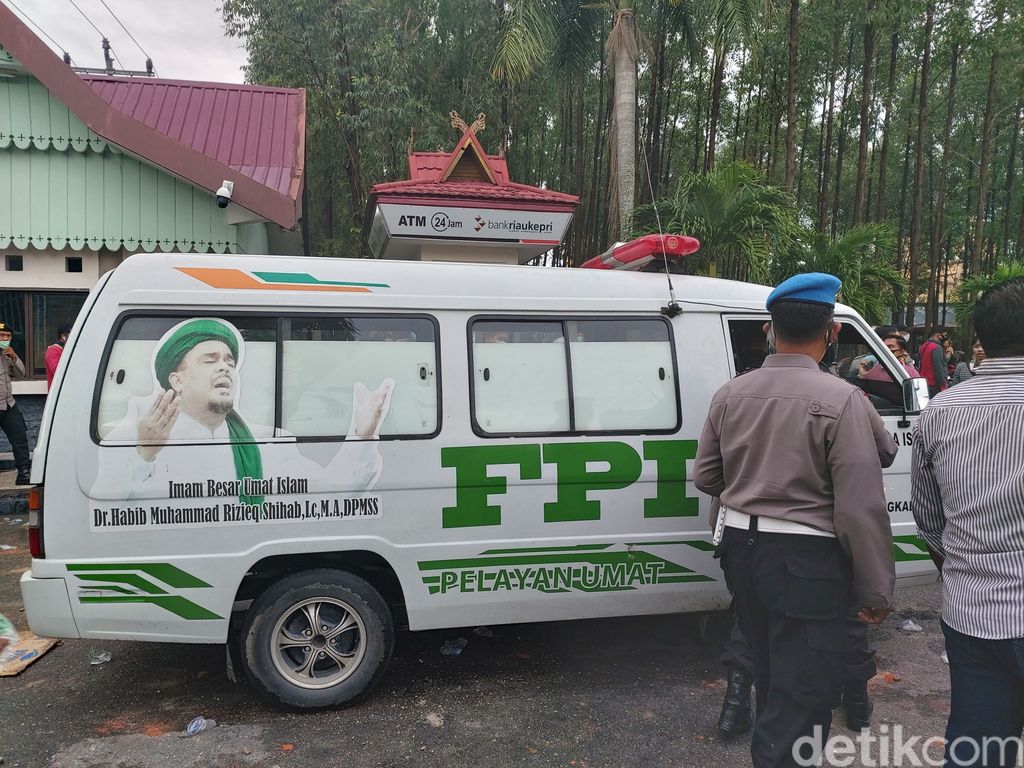 Ambulans bertuliskan FPI ditahan aparat karena menerobos kerumunan massa yang demo tolak Omnibus Law di DPRD Riau. Dua orang diamankan (Chaidir Tanjung/detikcom)