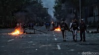 Sisa-sisa kerusuhan terlihat jelas di jalan raya.