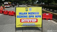 Sementara itu jalan menuju gedung DPR telah ditutup oleh polisi.