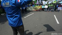 Dalam demo kali ini, massa juga membawa atribut aksi seperti spanduk dan poster tuntutan.