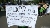 Poster kecaman dan kritik juga dibawa peserta aksi.