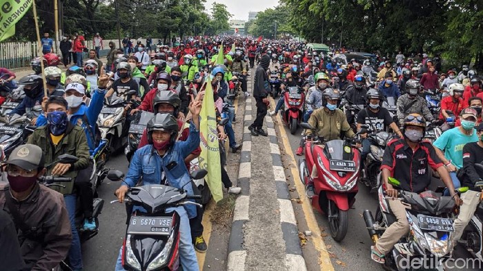 Polisi membuka blokade pagar betis di Jalan Daan Mogot Tangerang, Kamis (8/10). Alhasil, massa dari buruh dan pelajar mengalir ke arah Kalideres Jakarta Barat.