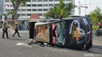 Mobil milik jatanras Polda Jatim dirusak dan diguilingkan massa di depan Hotel Inna Simpang.