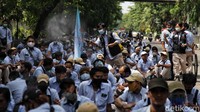 Para buruh disemprot disinfektaan untuk mencegah penyebaran COVID-19.