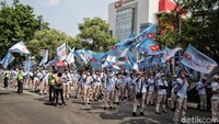 Selain berorasi, mereka juga mengibarkan bendera organisasi buruh.