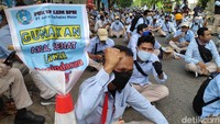 Para buruh juga membawa atribut aksi seperti poster.