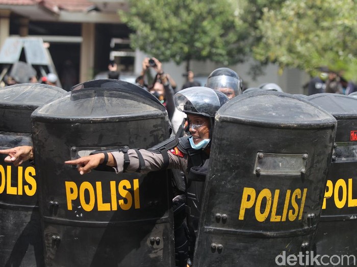 Massa melempari botol air mineral ke arah petugas Kepolisian yang berjaga di pintu masuk Gedung DPRD Provinsi Yogyakarta, Kamis (8/10/2020).