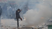 Massa aksi melemparkan batu dan benda tajam ke arah polisi.  