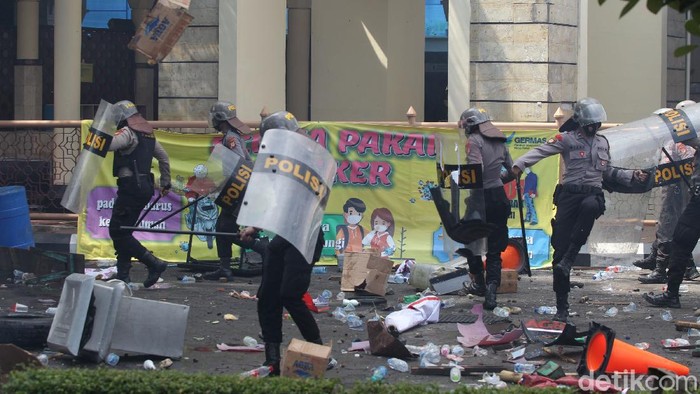 Massa melempari botol air mineral ke arah petugas Kepolisian yang berjaga di pintu masuk Gedung DPRD Provinsi Yogyakarta, Kamis (8/10/2020).