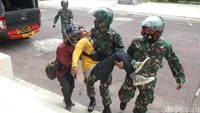 Aparat TNI membopong mahasiswa yang jatuh saat bentrokan terjadi.