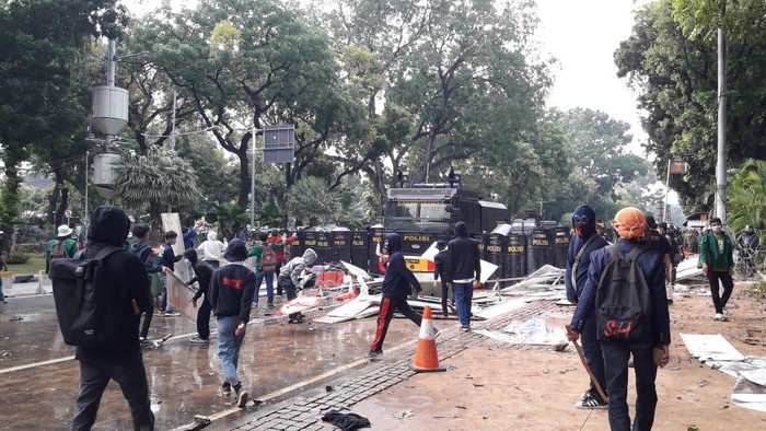 Polisi pukul mundur massa di Jalan Medan Merdeka Barat, Jakarta Pusat, ke arah patung kuda, Kamis (8/10/2020).