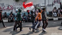 Seorang pengunjuk rasa mengibarkan bendera merah putih saat berjalan menuju istana merdeka.  