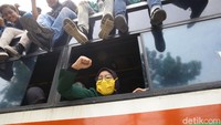 Seorang mahasiswi mengepalkan tangannya dari dalam bus.  