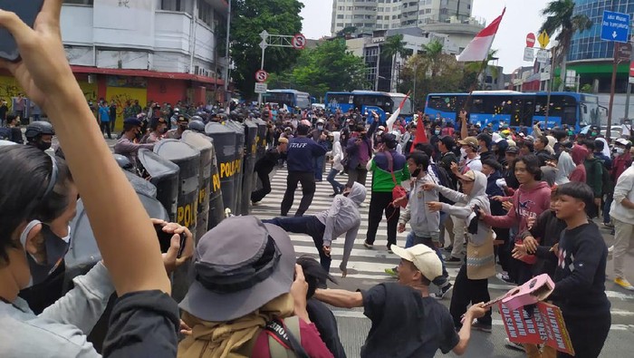 Massa demonstrasi UU Cipta Kerja melempari polisi dengan botol di Harmoni, Jakarta.