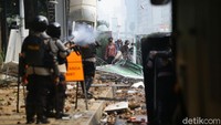 Mobil water canon mencoba memadamkan api dan menghalau massa. Massa mundur setelah ada tembakan gas air mata.