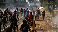 Massa aksi melempari polisi dengan batu dan botol.