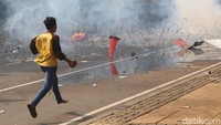 Momen saat seorang masa hendak melemparkan batu ke arah petugas.