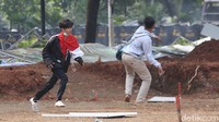 Massa memanfaatkan batu yang ada di lokasi untuk menyerang petugas.