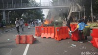 Terlihat separator jalan dibakar untuk menghalau petugas.