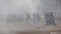 Petugas memukul mundur massa dengan menembakkan gas air mata.
