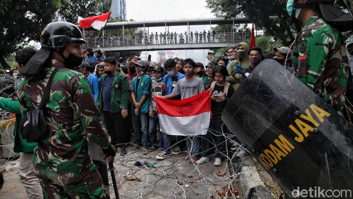Puluhan personel TNI AD dair Kodam Jaya membuat barikade dan mencoba menenangkan massa. Ini foto-fotonya yang bikin hati adem.