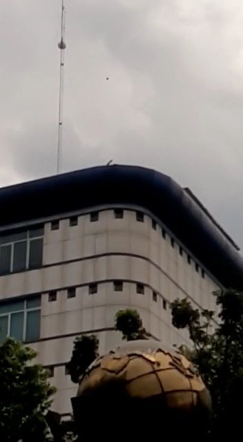 Screenshot of a mysterious man throwing stones from the top of the Medan DPRD building into the crowd of protesters (Special doc)