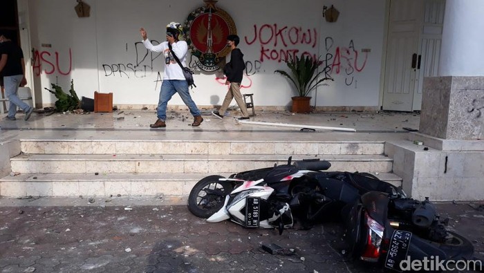 Massa aksi tolak Omnibus Law UU Cipta Kerja yang ricuh di kantor DPRD DIY mengakibatkan sejumlah fasilitas rusak. Tembok DPRD tampak dicoret-coret, bahkan sejumlah mobil mengalami kaca pecah.