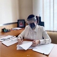 Berada di ruangan kerjanya untuk membuat laporan hasil pengumpulan data mengenai banjir, Tina Toon mengunggah foto yang memperlihatkan penampilannya memakai busana serba putih. Dia bekerja di kantor dengan tetap memakai face shield dan masker. Foto: Instagram @tinatoon101